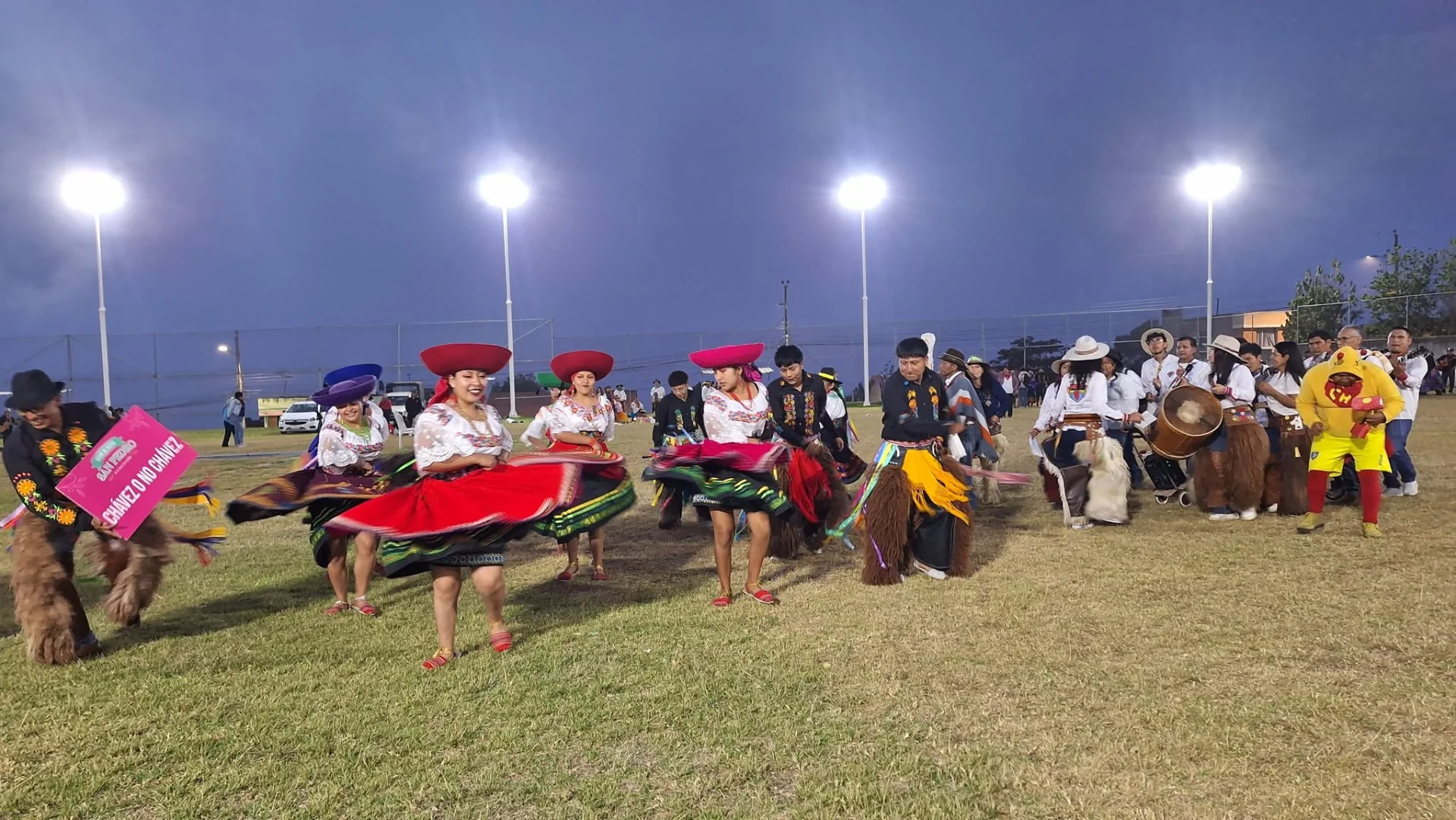 Bailarinas con faldas rojas y músicos celebran el encuentro interparroquial en el estadio de Chavezpamba.